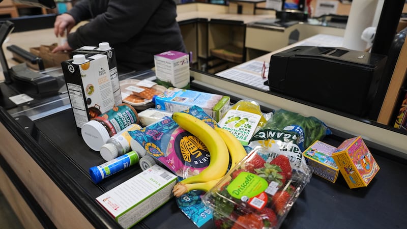 A cashier scans groceries, including produce, which is covered by the USDA Supplemental...