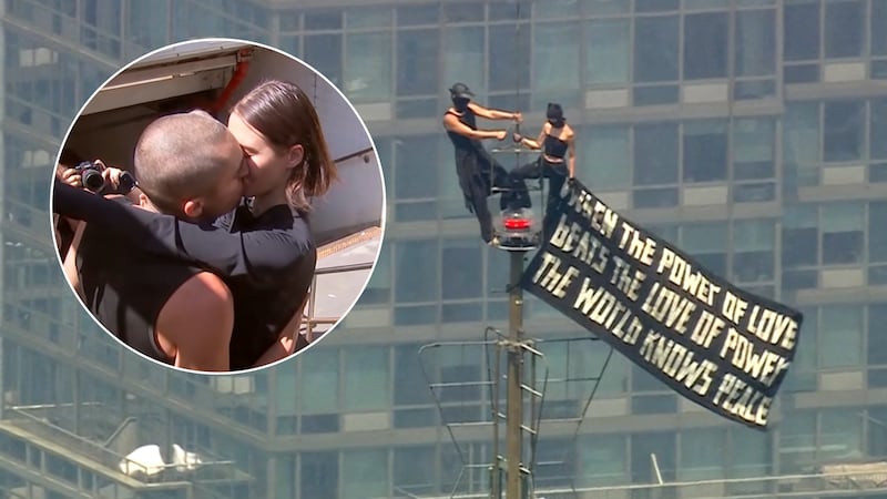 The couple who climbed the Empire State Building Wednesday to get engaged shared a kiss after...