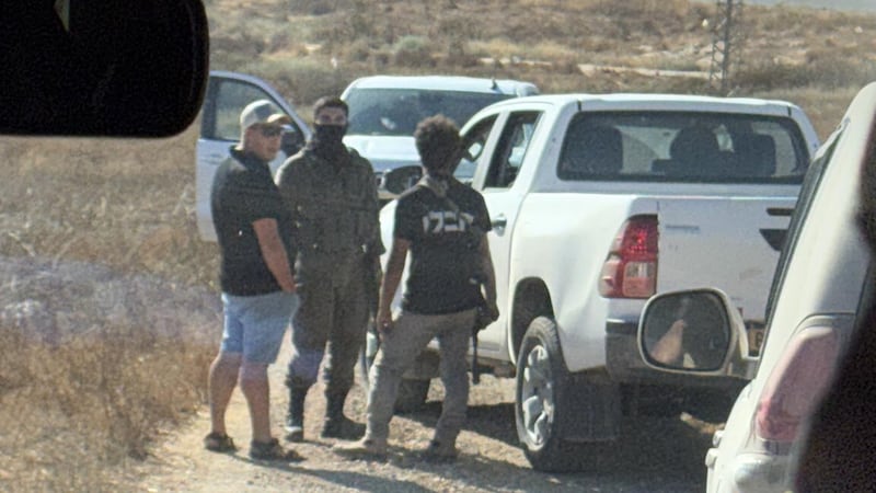 In this photo provided by Cameron Kasky, armed men block the road, stopping vehicles...